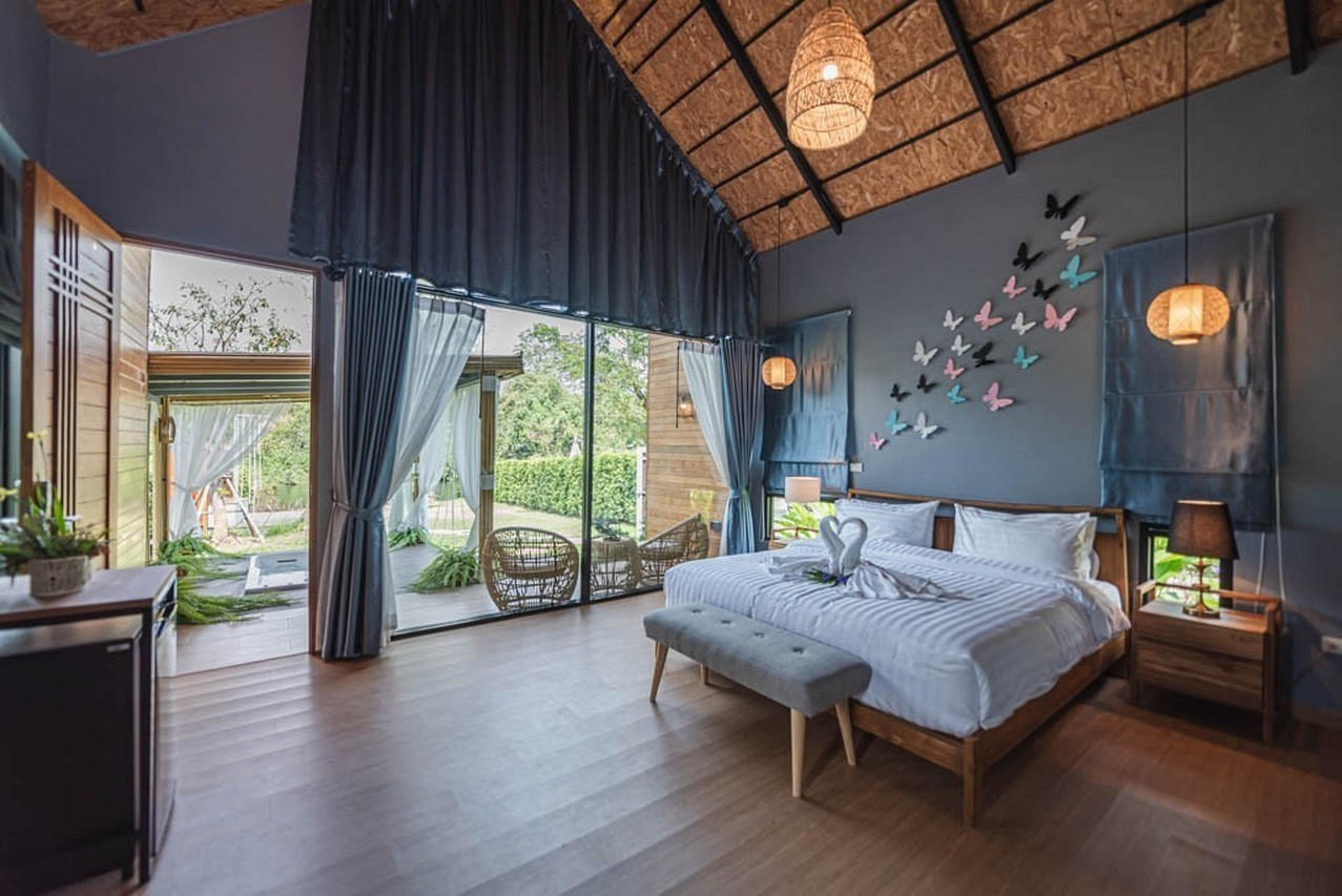 ห้องวิลล่าหลังคาจั่วสูง ผนังตกแต่งผีเสื้อ เปิดประตูสู่สวนริมน้ำที่ The Tree Riverside