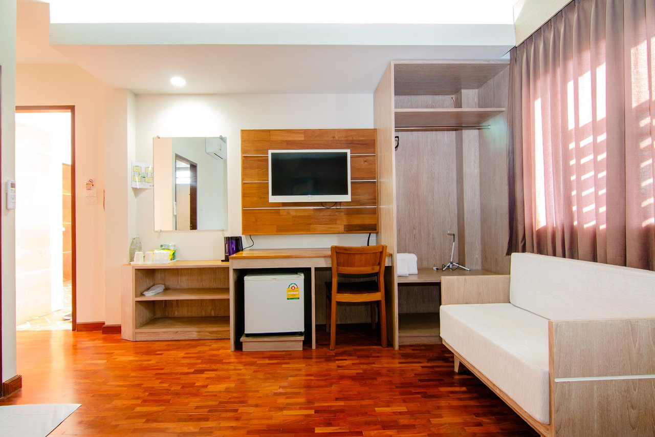 ห้องพัก Orchid Place Hotel พื้นไม้ ทีวี โต๊ะทำงานและตู้เย็นเล็ก