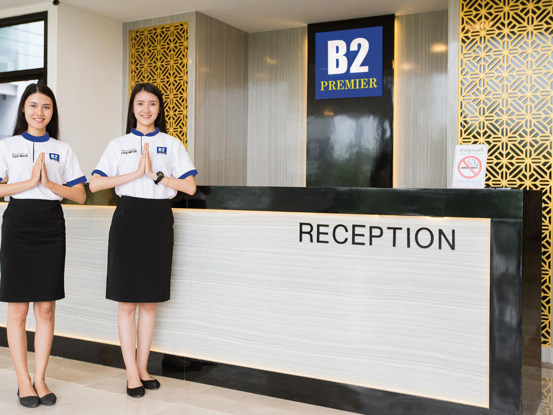 เคาน์เตอร์ต้อนรับ B2 Premier พร้อมพนักงานยกมือไหว้ที่ B2 Phitsanulok Premier Hotel