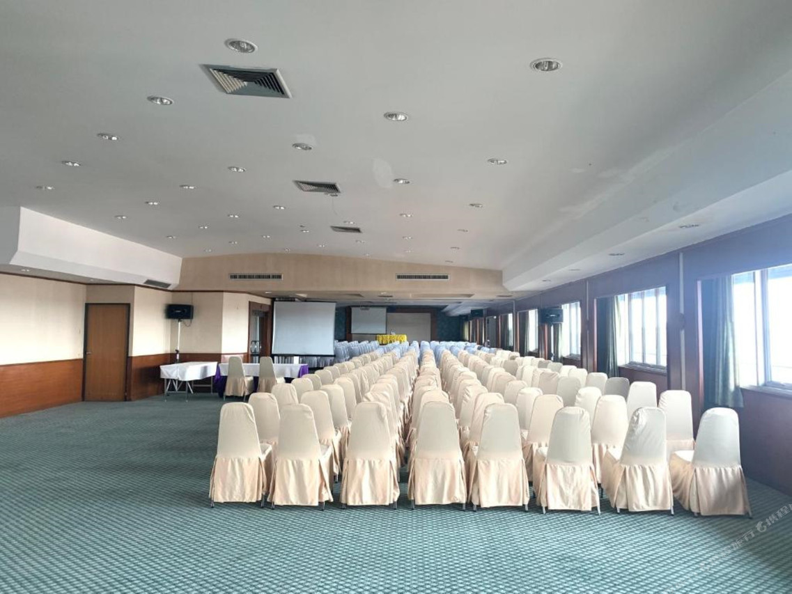 ห้องประชุมขนาดใหญ่พร้อมจอโปรเจกเตอร์และเก้าอี้คลุมผ้า