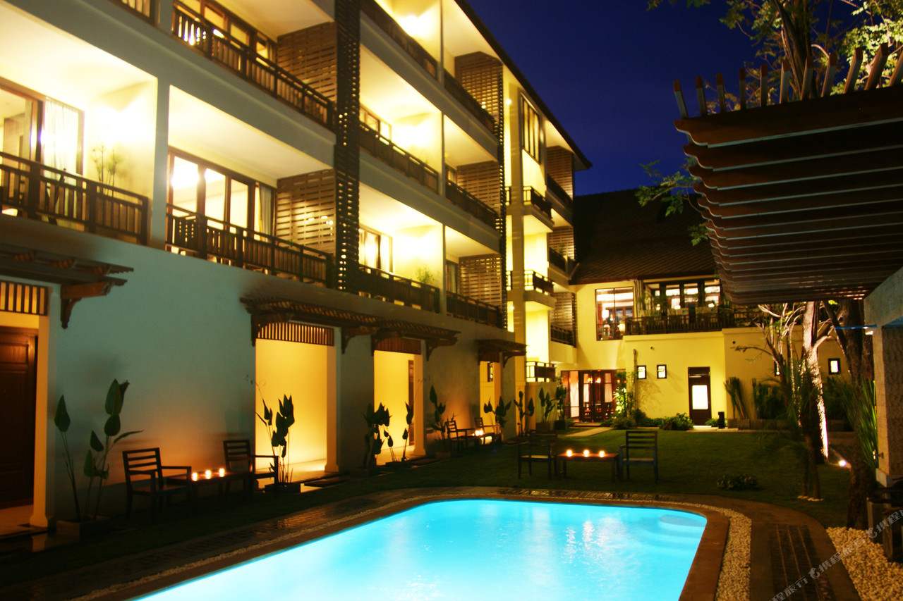 สระว่ายน้ำกลางแจ้งและระเบียงห้องพักเรือนไม้ทรงไทยตอนกลางคืน