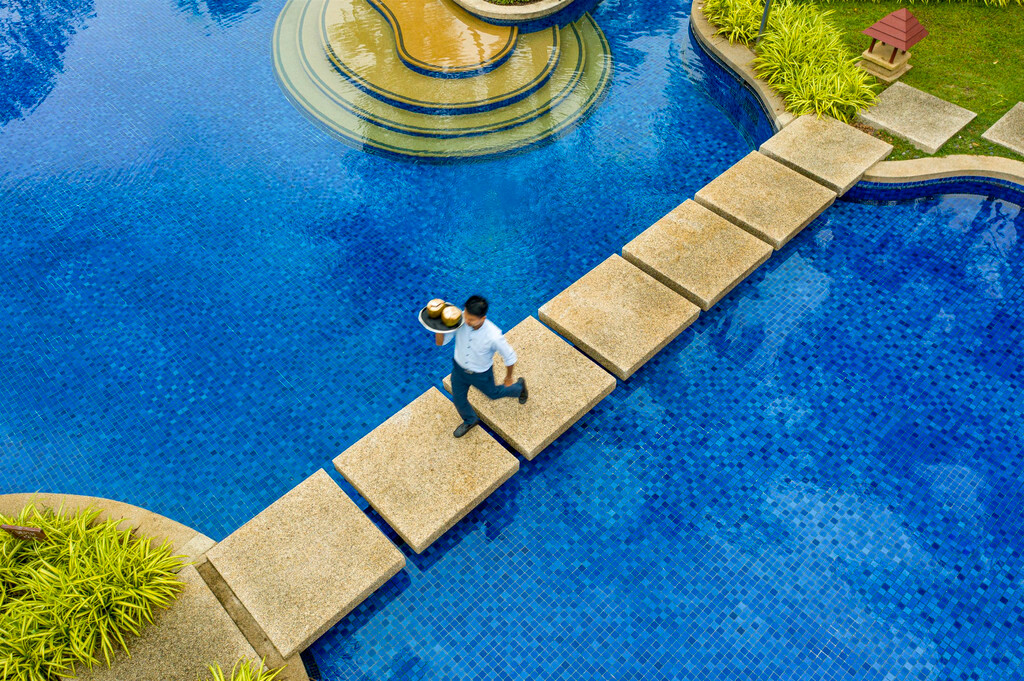 สระว่ายน้ำลากูนสีฟ้ากับทางเดินหินกลางสระ Banyan Tree Phuket