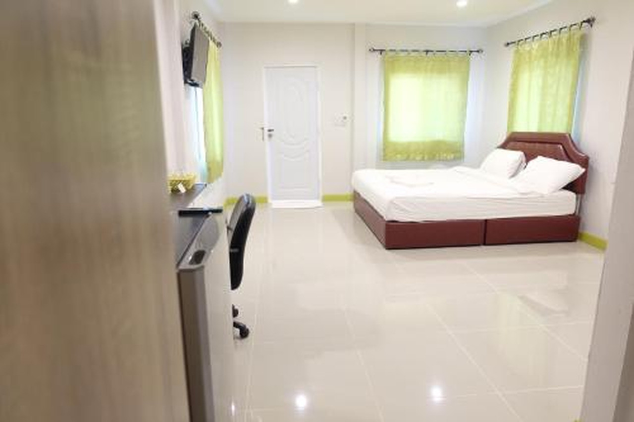 ห้องพักโทนขาวสะอาดที่ Deva Garden Resort ปราจีนบุรี พื้นกระเบื้องขาว เตียงใหญ่ ผ้าม่านสีเขียว