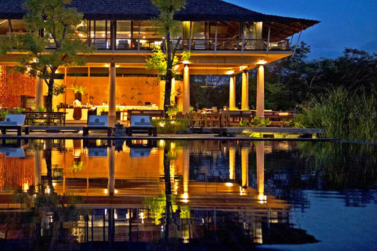 Acala restaurant pavilion lit up at dusk, reflected in the water