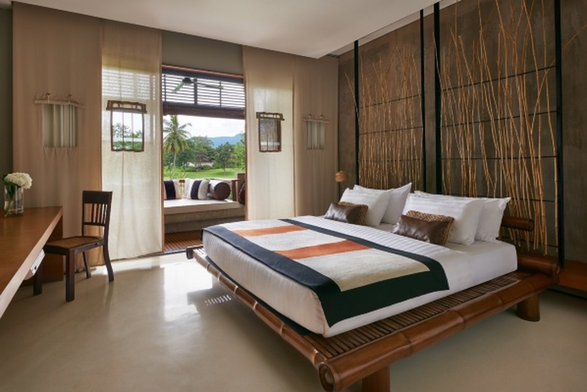 Deluxe room with a bamboo headboard wall and a window daybed facing the fairways