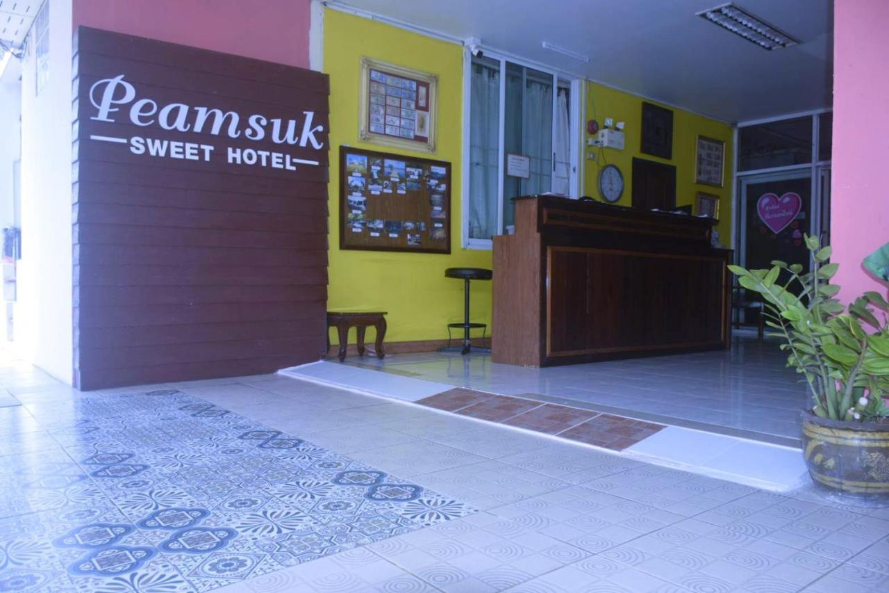 เคาน์เตอร์ต้อนรับ Peamsuk Sweet ปราจีนบุรี ป้ายไม้สีน้ำตาลผนังสีเหลือง