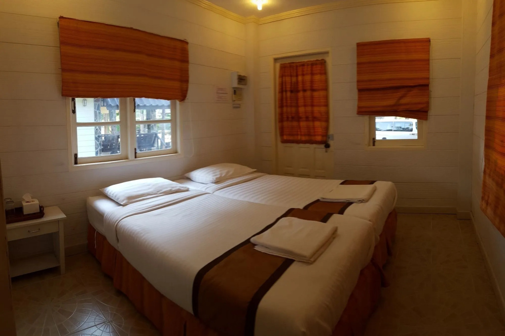 ห้องบ้านไม้ผนังขาวเตียงคู่ มีประตูออกสวน Prachuap Garden View Resort