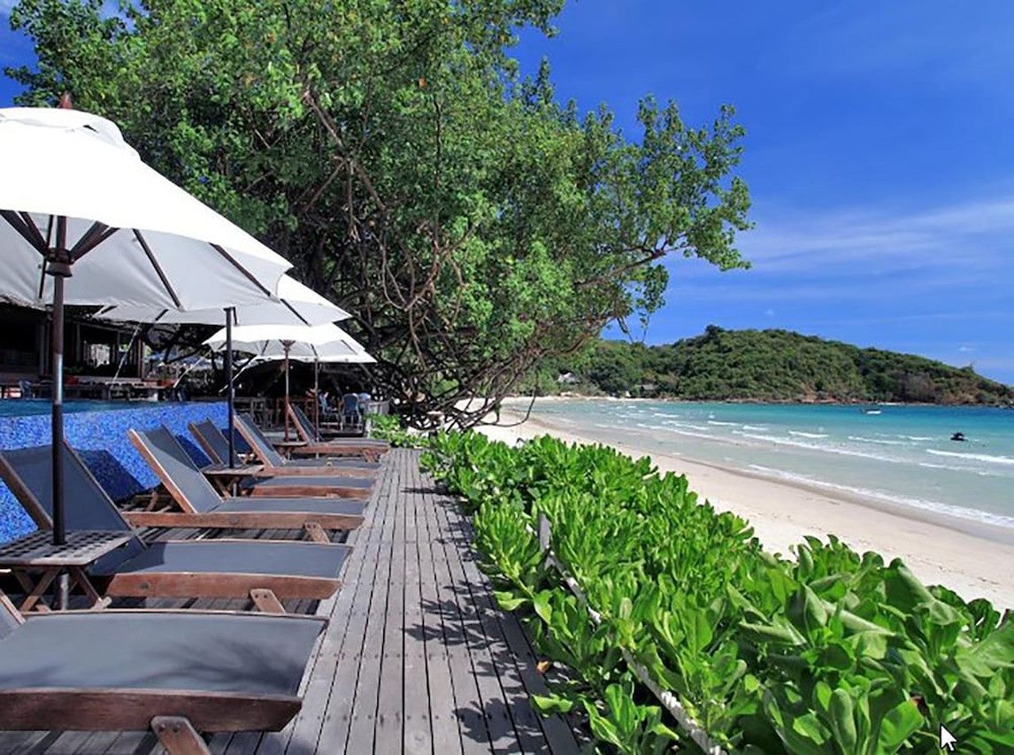 เตียงผ้าใบและร่มขาวเรียงรายริมหาดทรายขาวอ่าวพร้าว