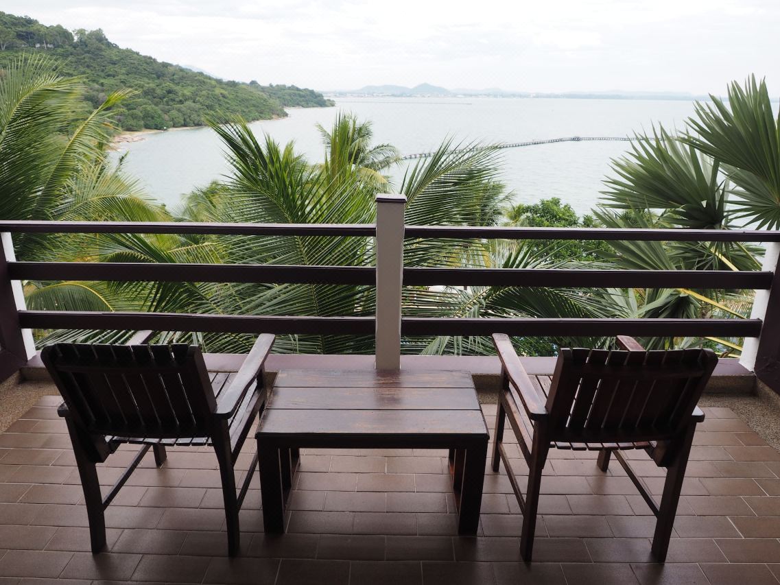 Guest-room balcony with wooden chairs looking out over the bay