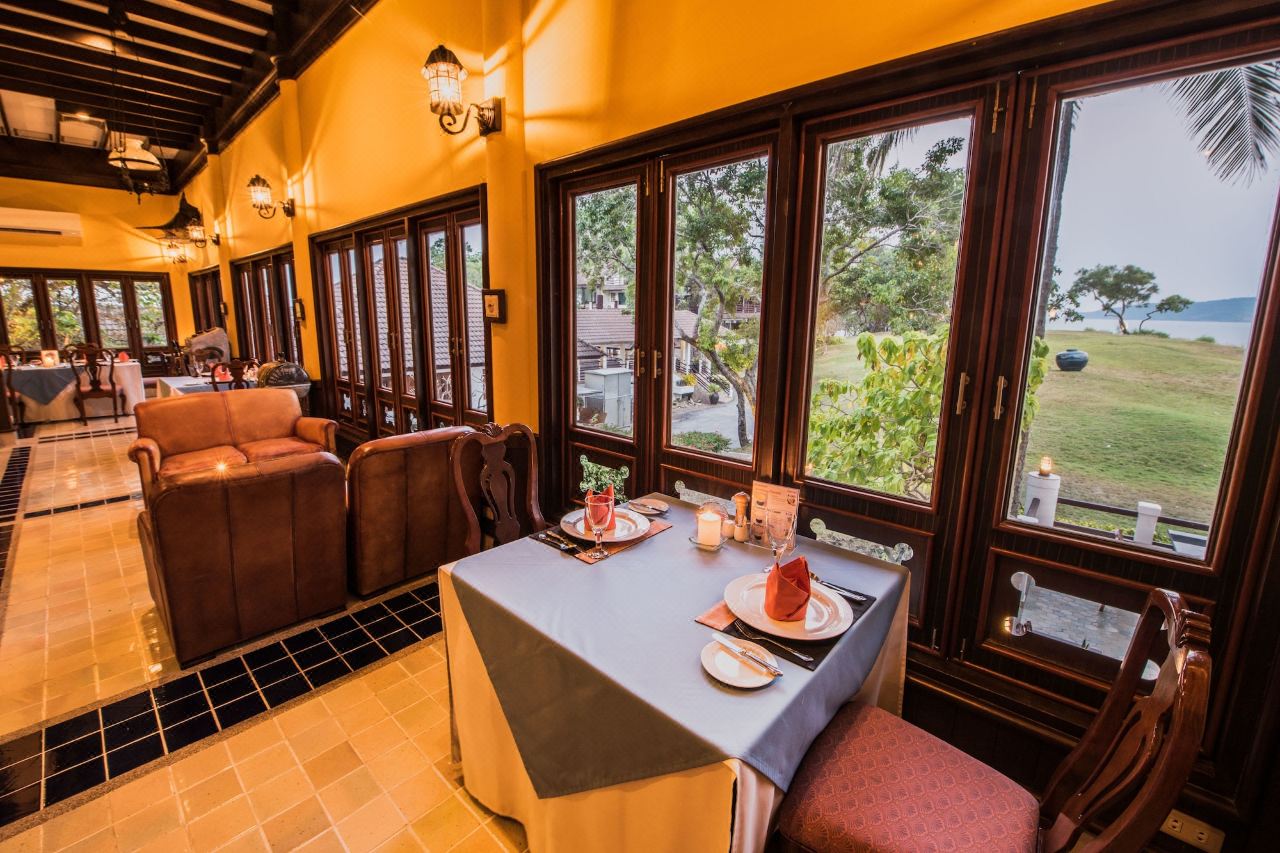 Captain's Table restaurant with garden and sea views through large wooden windows