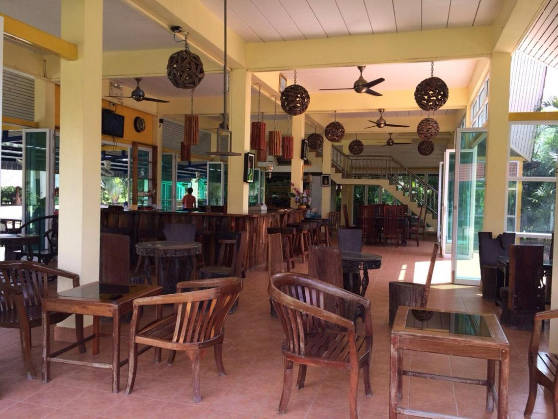 Open-air restaurant with rattan pendant lamps and teak furniture at Aranyaprathet Riverside Resort