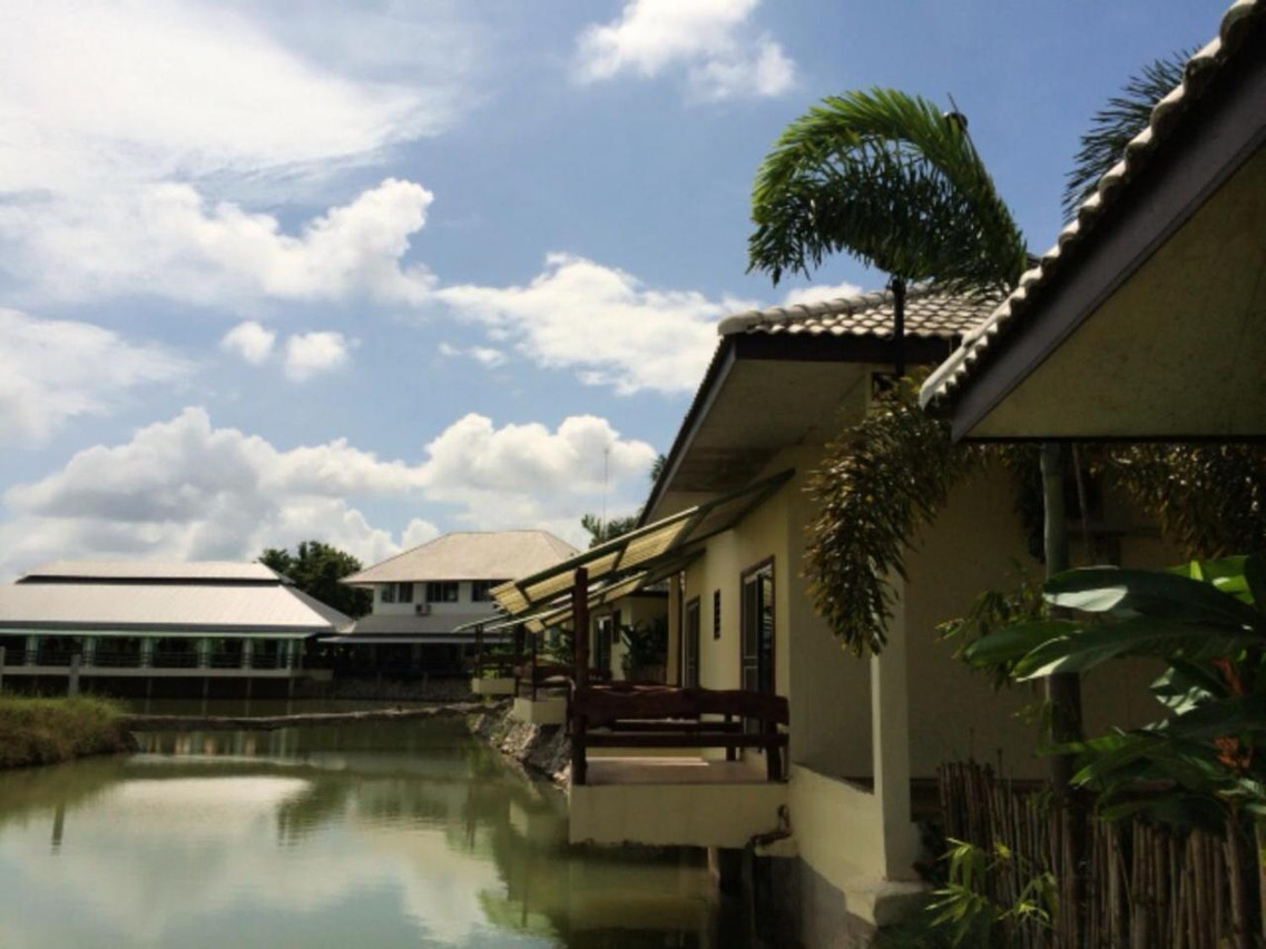 Lakeside teak bungalow with a private deck extending over the water