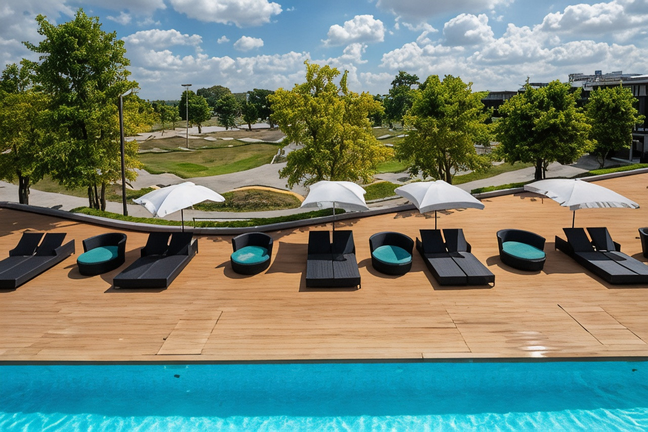 สระว่ายน้ำกลางแจ้งและเตียงอาบแดดของ The VELO'S Hotel มองเห็นสนาม Pump Track ด้านหลัง