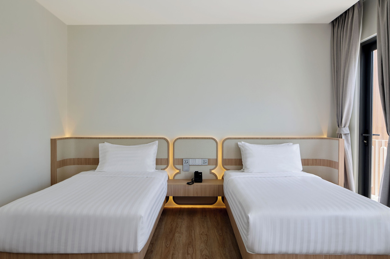 ระเบียงห้องมุมโค้งพร้อมเก้าอี้ มองคลองมหาชัยและป่าชายเลน ที่ Phetara Hotel Mahachai