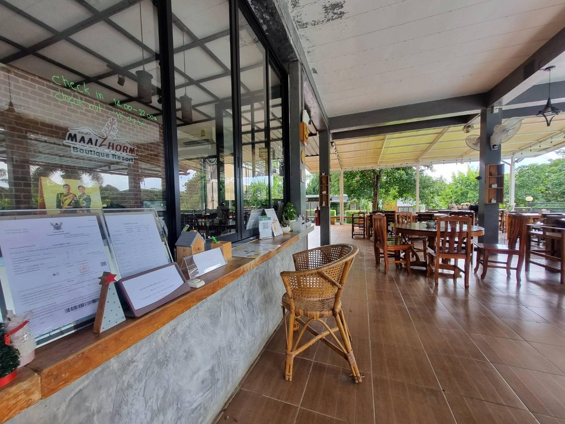 Semi-outdoor restaurant terrace with timber tables looking onto the garden