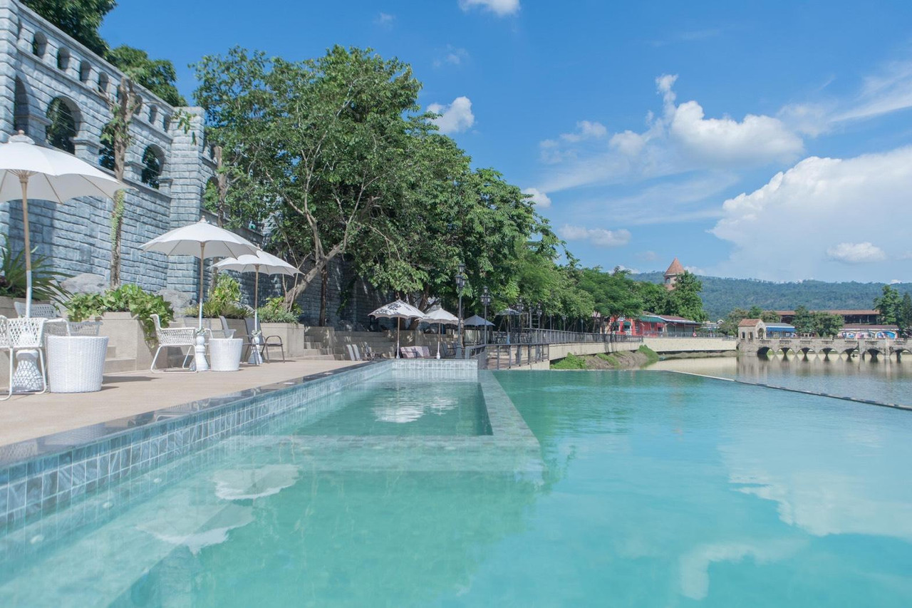สระ Infinity ของ The Verona at Tublan ยื่นลงทะเลสาบ มองเห็นกำแพงหินและแนวเขา