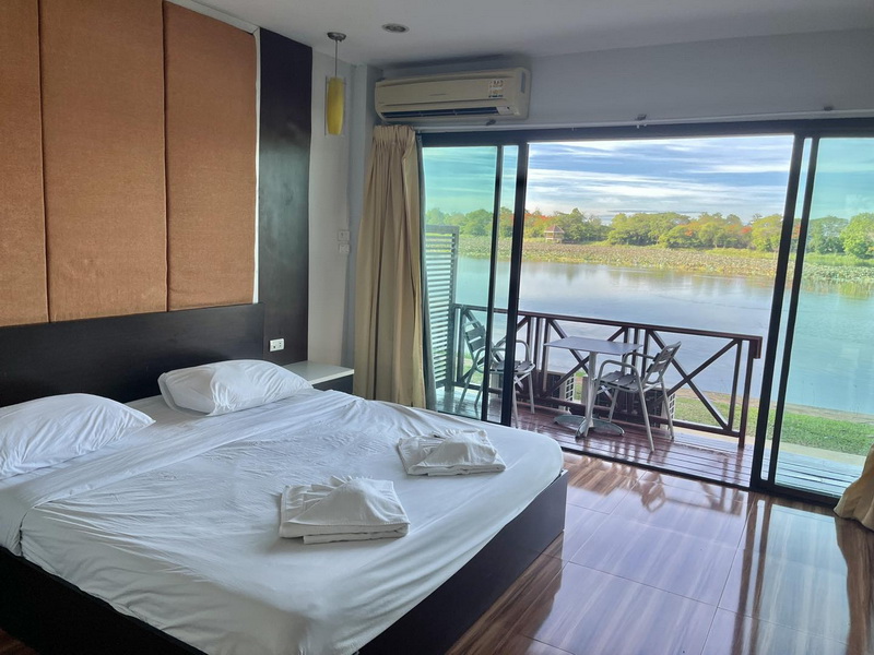 ห้องพักเตียงใหญ่ มองออกระเบียงเห็นบึงฉวาก ที่ Bungchawak Resort