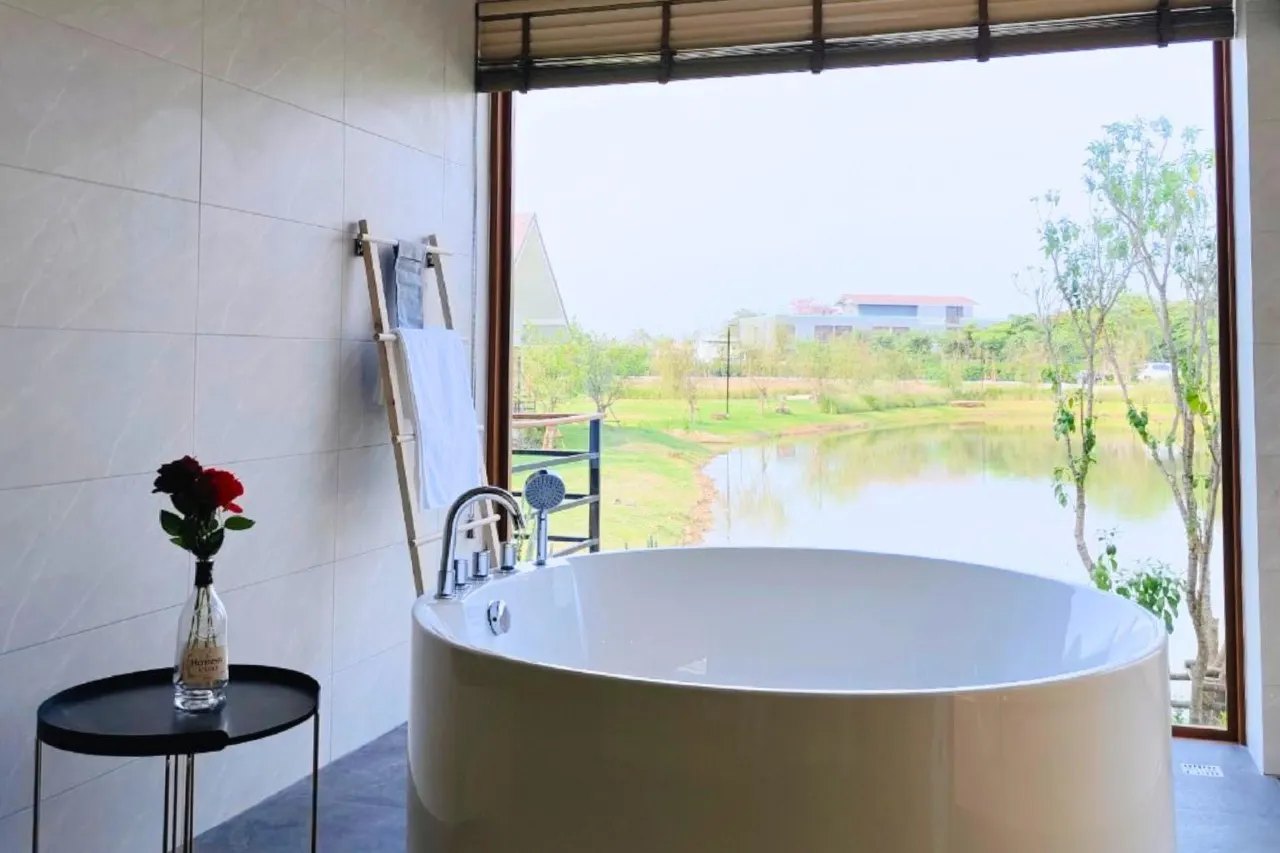 อ่างอาบน้ำกลมในห้องน้ำ หันหน้าออกหน้าต่างบานใหญ่มองวิวน้ำ