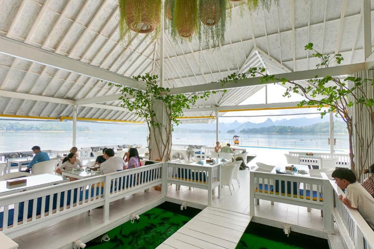 ภายในร้านอาหารลอยน้ำ มองเห็นทะเลสาบและแนวเขาหินปูนเขาสก