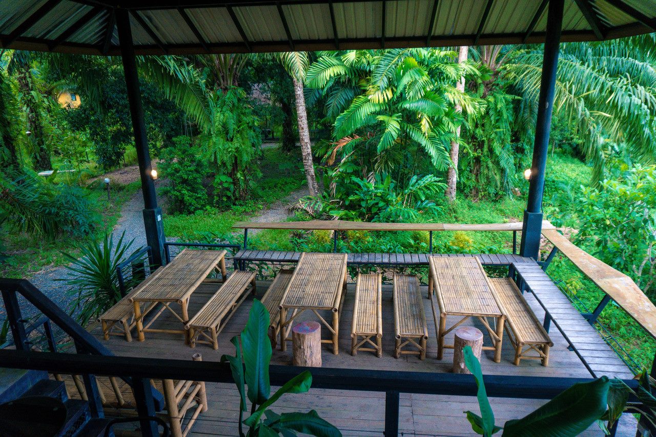 Bamboo seating in an open sala among the jungle garden at Anurak Community Lodge