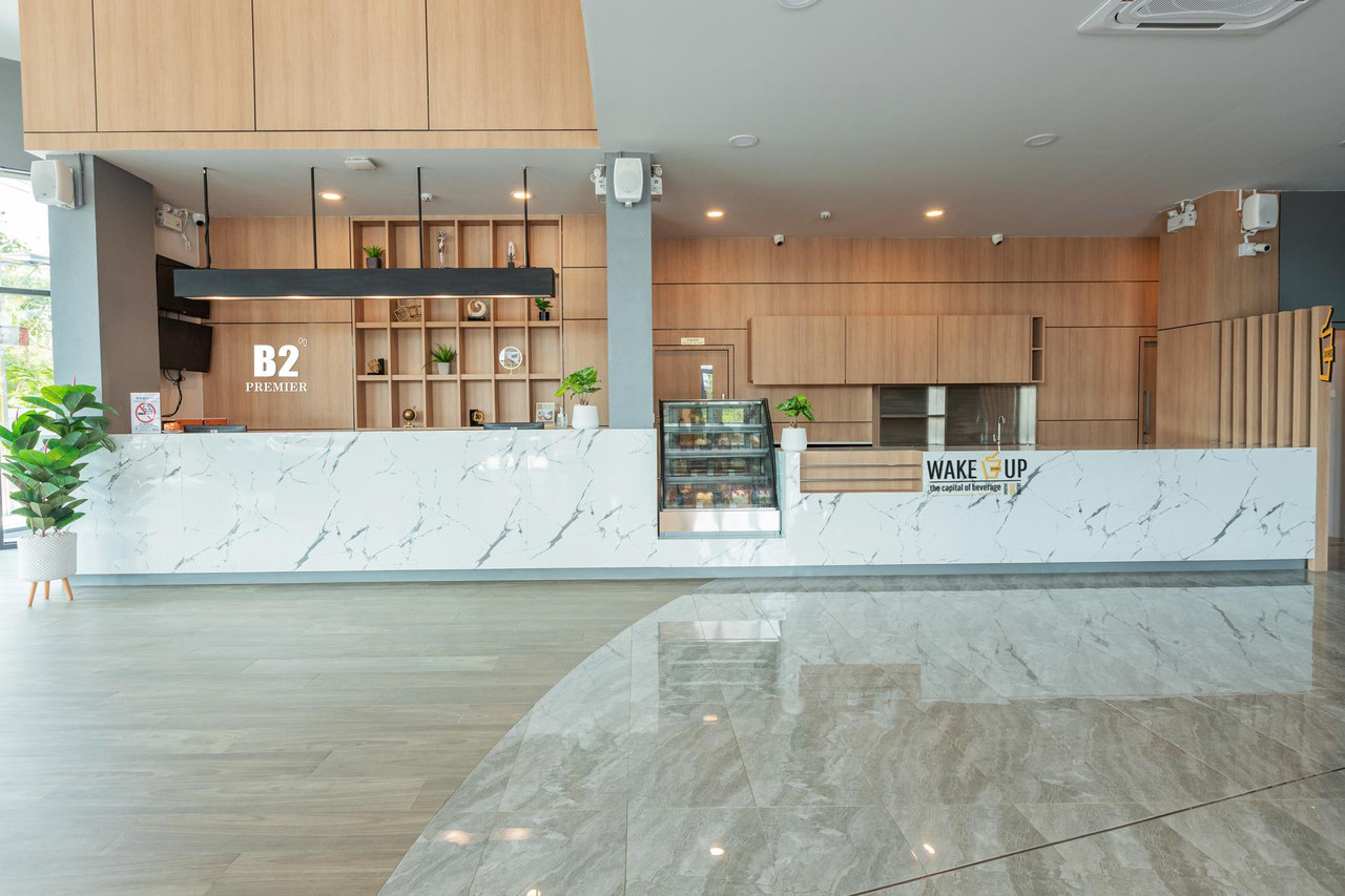 Reception desk with B2 Premier signage and a Wake Up coffee corner