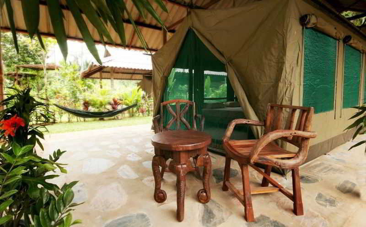 เต็นท์ Safari ของ Elephant Hills พร้อมระเบียงและเปลญวนกลางสวน