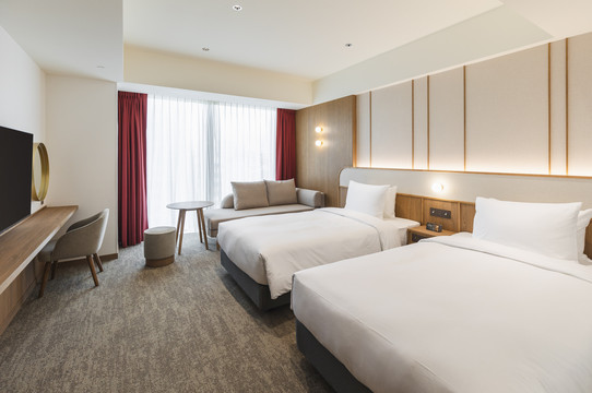 Deluxe Twin room — twin beds, wood-toned interior, deep-red curtains