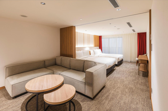 Grand Twin room at Sotetsu Grand Fresa Taipei Ximen — large sofa, two beds, warm Japanese tones