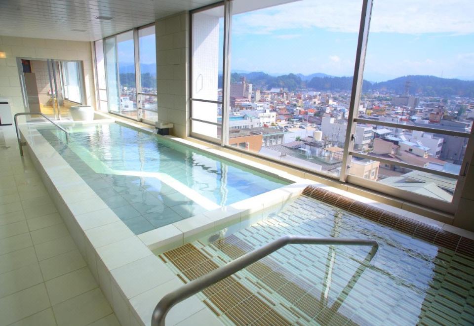 อ่างออนเซ็นน้ำพุร้อนบนชั้น 9 ของ Spa Hotel Alpina วิวเมืองทาคายามะและภูเขาฮิดะ