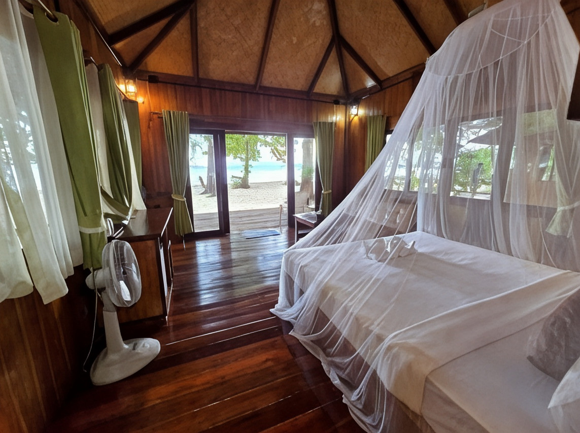 ภายในบังกะโลไม้มีมุ้งกันยุงและพัดลม ประตูเปิดออกถึงหาดทรายขาว Kradan Beach Resort เกาะกระดาน