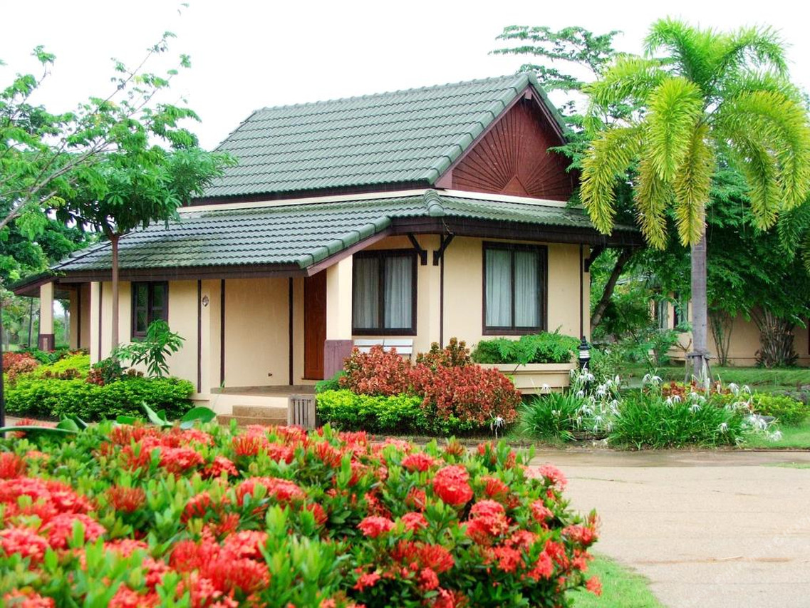 Shaded resort pathway lined with trees and tropical flowering plants