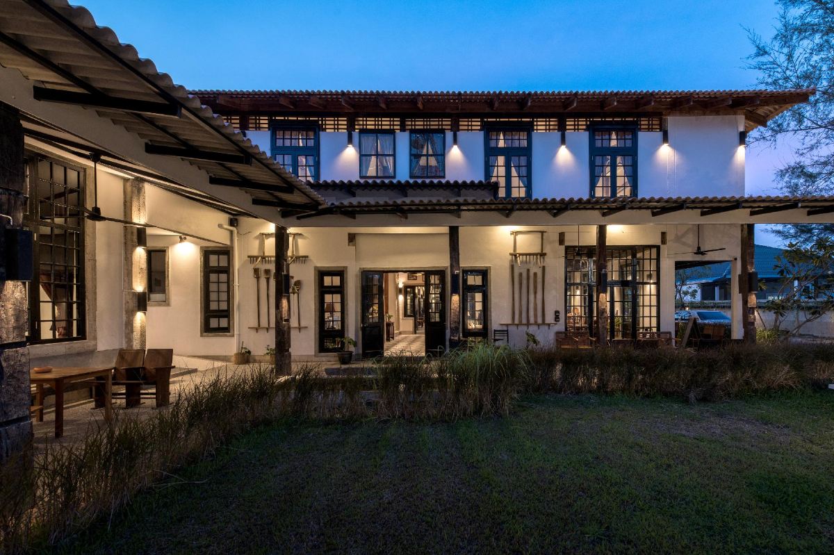อาคารไม้สองชั้นรอบลานหญ้าและลานเสาธงของ Uthai Heritage Hotel อุทัยธานี