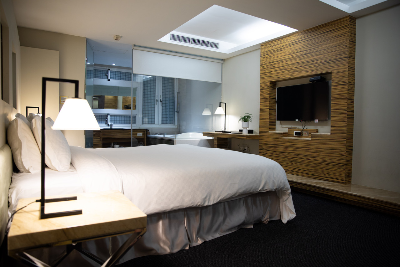 ห้องพัก King Suite ดีไซน์เนอร์พร้อมอ่างอาบน้ำและผนังไม้ลายริ้ว